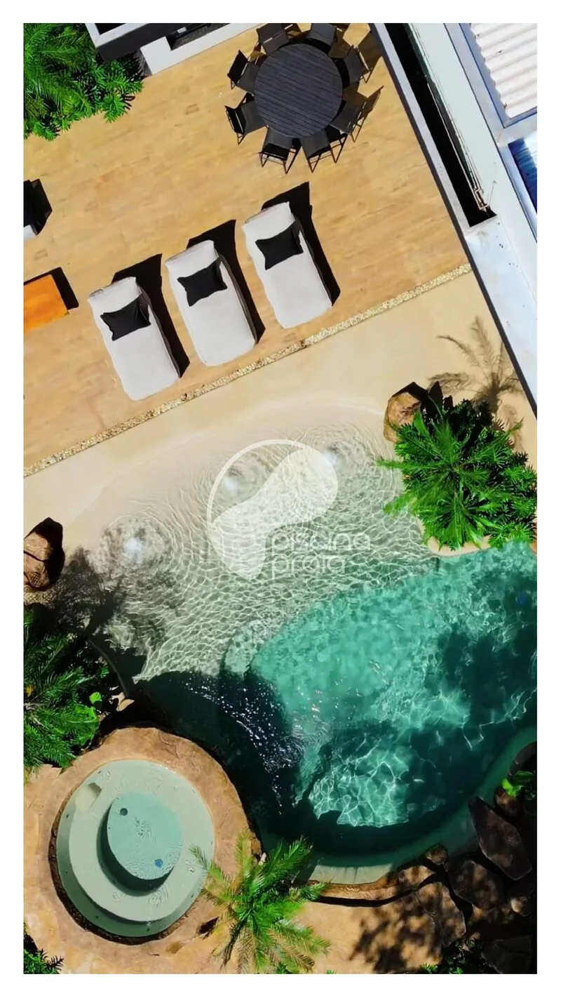 Vista de cima da piscina com prainha, hidromassagem e espreguiçadeiras